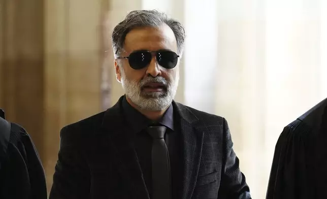 Abderrahmane Ouatiki, who was working as a hotel receptionist and was allegedly held at gunpoint by the robbers during the 2016 armed robbery of Kim Kardashian, arrives at the palace of justice Monday, April 28, 2025 in Paris. (AP Photo/Aurelien Morissard)