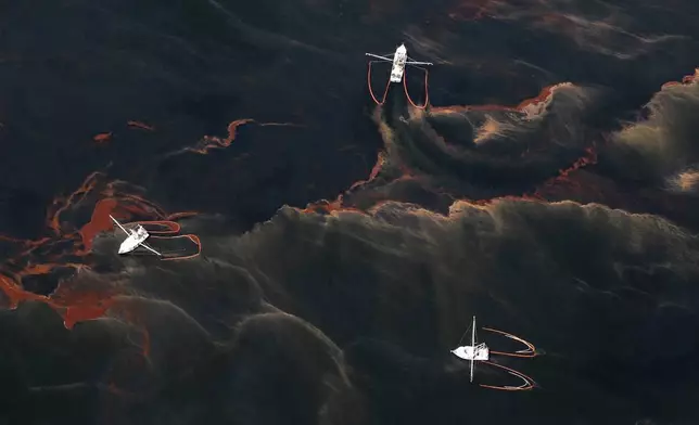 FILE - Shrimp boats are used to collect oil with booms in the waters of Chandeleur Sound, La., May 5, 2010. (AP Photo/Eric Gay, File)