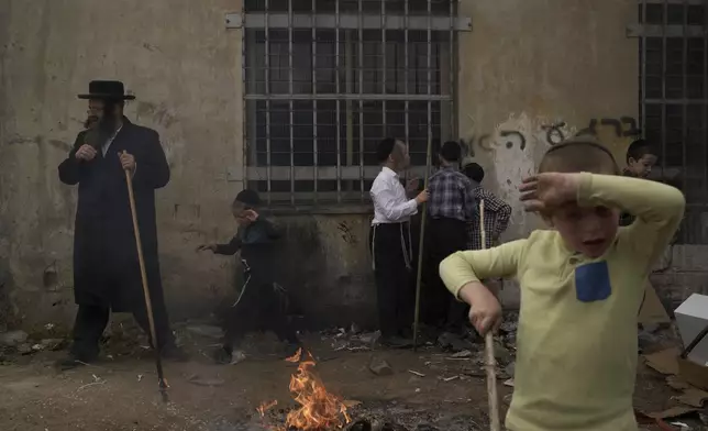 Ultra-Orthodox Jewish men and children burn leavened items in final preparation for the Passover holiday in the ultra-Orthodox Jewish town of Bnei Brak, near Tel Aviv, Israel, Friday, April 11, 2025. (AP Photo/Leo Correa)