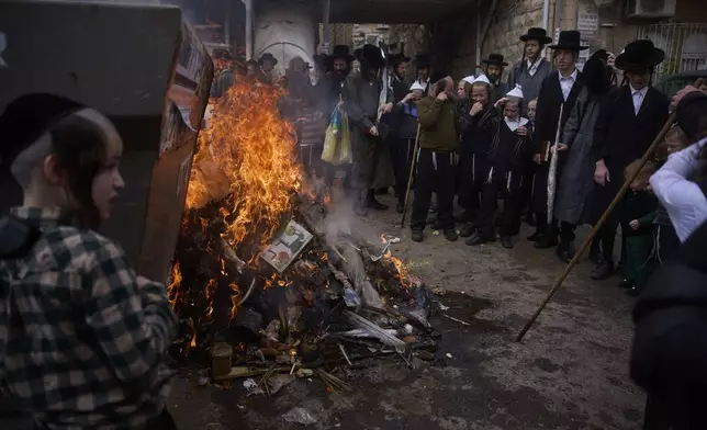 Ultra-Orthodox Jewish men and children burn leavened items in final preparation for the Passover holiday in the Orthodox neighbourhood of Mea Shearim in Jerusalem, Friday, April 11, 2025. (AP Photo/Ohad Zwigenberg)