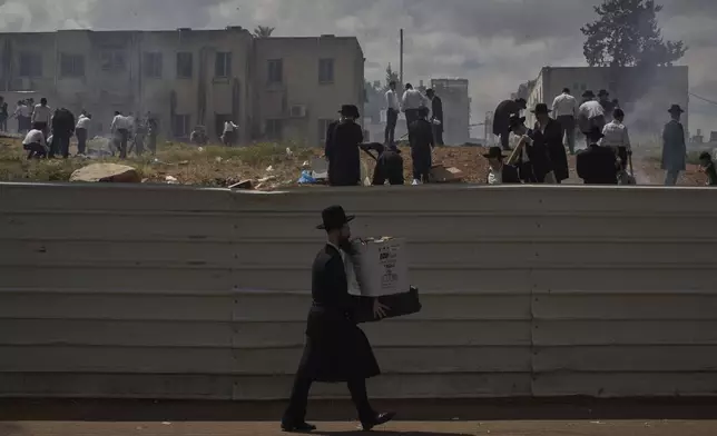 Ultra-Orthodox Jewish men and children burn leavened items in final preparation for the Passover holiday in the ultra-Orthodox Jewish town of Bnei Brak, near Tel Aviv, Israel, Friday, April 11, 2025. (AP Photo/Leo Correa)