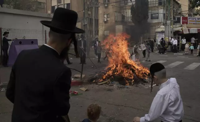 Ultra-Orthodox Jewish men and children burn leavened items in final preparation for the Passover holiday in the ultra-Orthodox Jewish town of Bnei Brak, near Tel Aviv, Israel, Friday, April 11, 2025. (AP Photo/Leo Correa)