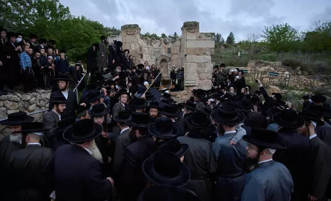 Ultra-Orthodox Jewish men gather to collect water from a spring to make matzoh, a traditional handmade unleavened bread for the holiday of Passover, during the Maim Shelanu ceremony at a mountain spring in the outskirts of Jerusalem, Thursday, April 10, 2025. (AP Photo/Ohad Zwigenberg)