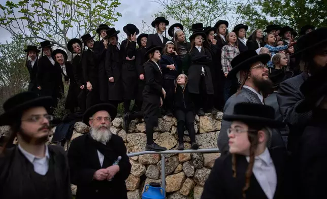 Ultra-Orthodox Jewish men gather to collect water from a spring to make matzoh, a traditional handmade unleavened bread for the holiday of Passover, during the Maim Shelanu ceremony at a mountain spring in the outskirts of Jerusalem, Thursday, April 10, 2025. (AP Photo/Ohad Zwigenberg)