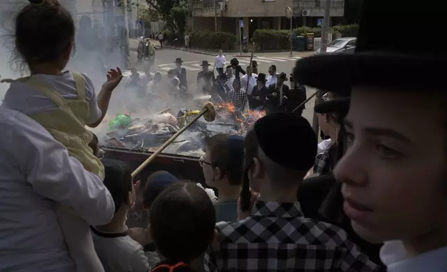 Ultra-Orthodox Jewish men and children burn leavened items in final preparation for the Passover holiday in the ultra-Orthodox Jewish town of Bnei Brak, near Tel Aviv, Israel, Friday, April 11, 2025. (AP Photo/Leo Correa)