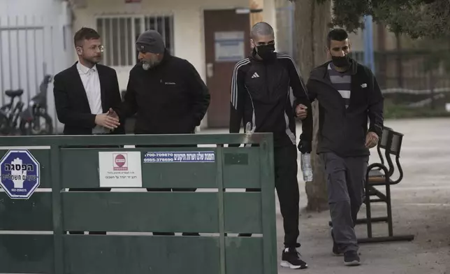 Palestinian Ahmed Manasra , second right, who took part in an attack in 2015 when he was 13 and developed schizophrenia in prison, walks during his release in Jerusalem, Thursday, April 10, 2025. (AP Photo/Mahmoud Illean)