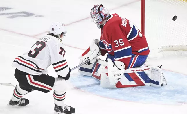 Chicago Blackhawks' Lukas Reichel (73) scores against Montreal Canadiens goaltender Sam Montembeault (35) during third-period NHL hockey game action in Montreal, Monday, April 14, 2025. (Graham Hughes/The Canadian Press via AP)