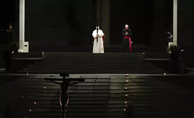FILE - Pope Francis presides over the Via Crucis – or Way of the Cross – ceremony in St. Peter's Square, empty of the faithful following Italy's ban on gatherings to contain the COVID-19 contagion, at the Vatican, Friday, April 10, 2020. (AP Photo/Alessandra Tarantino, file)