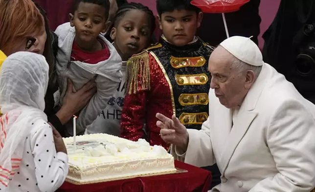 FILE - Pope Francis blows a candle on a cake as he celebrates his 87th birthday with children assisted by the Santa Marta dispensary during an audience in the Paul VI Hall, at the Vatican, Sunday, Dec. 17, 2023. (AP Photo/Alessandra Tarantino, file)