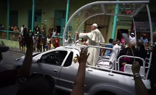 FILE - People wave to Pope Francis as he leaves the Metropolitan Cathedral, in route to the airport in Santiago de Cuba, Cuba, on Tuesday, Sept. 22, 2015. (AP Photo/Ramon Espinosa, file)