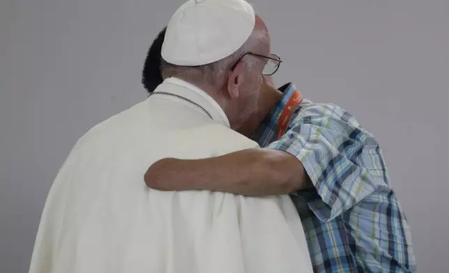 FILE - Former FARC rebel Carlos Juan Carlos Murcia, who lost his left hand, embraces Pope Francis during a prayer meeting for reconciliation at Las Malocas Park in Villavicencio, Colombia, Friday, Sept. 8, 2017. (AP Photo/Andrew Medichini, file)