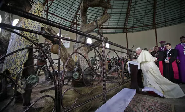 FILE - Pope Francis kneels in prayer during his visit at the Anglican martyrs' shrine of Namugongo, Kampala, Uganda, Saturday, Nov. 28, 2015. (AP Photo/Andrew Medichini, Pool, file)