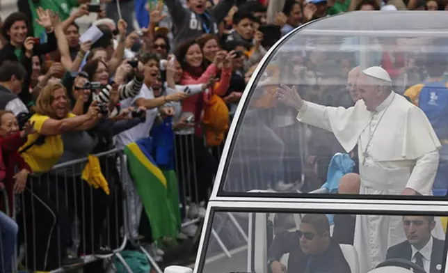 FILE - Pope Francis waves from the popemobile as he rides along the Copacabana beachfront on his way to celebrate mass for World Youth Day, in Rio de Janeiro, Brazil, Sunday, July 28, 2013. (AP Photo/Silvia Izquierdo, File)