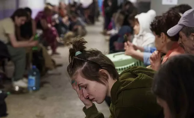 A woman sits in a school basement being used as a shelter after a Russian airstrike on a residential neighborhood in Kyiv, Ukraine, on Thursday, April 24, 2025. (AP Photo/Evgeniy Maloletka)