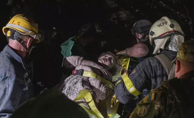 Rescue workers evacuate an injured woman from the rubble of a house destroyed by a Russian airstrike in a residential neighborhood in Kyiv, Ukraine, on Thursday, April 24, 2025. (AP Photo/Evgeniy Maloletka)