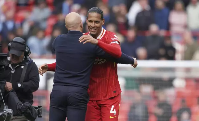 Liverpool's manager Arne Slot celebrates with Liverpool's Virgil van Dijk at the end of the English Premier League soccer match between Liverpool and West Ham United at Anfield in Liverpool, Sunday, April 13, 2025. (AP Photo/Ian Hodgson)