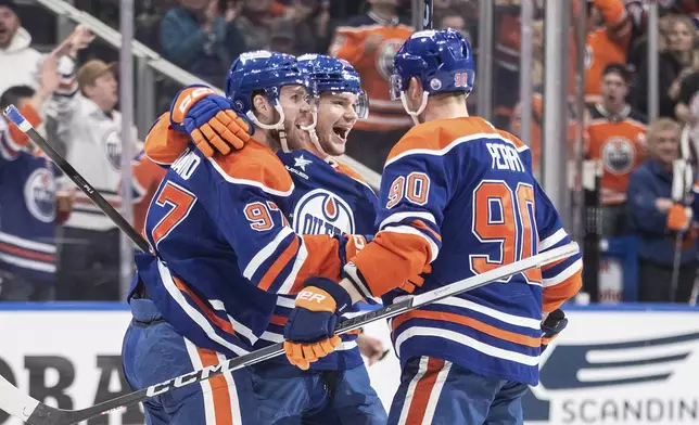 Edmonton Oilers' Connor McDavid (97), Vasily Podkolzin (92) and Corey Perry (90) celebrate a goal against the St. Louis Blues during the second period of an NHL game in Edmonton on Wednesday, April 9, 2025. (Jason Franson/The Canadian Press via AP)