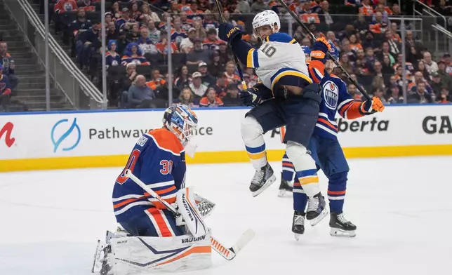 St. Louis Blues' Brayden Schenn (10) jumps as Edmonton Oilers goalie Calvin Pickard (30) makes the save during the third period of an NHL game in Edmonton on Wednesday, April 9, 2025. (Jason Franson/The Canadian Press via AP)