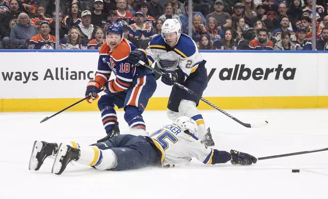 St. Louis Blues' Tyler Tucker (75) blocks the pass as Ryan Suter (22) and Edmonton Oilers' Zach Hyman (18) battle for position the second period of an NHL game in Edmonton on Wednesday, April 9, 2025. (Jason Franson/The Canadian Press via AP)