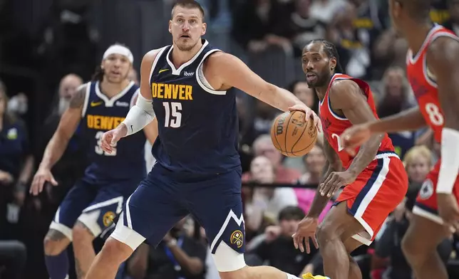 Denver Nuggets center Nikola Jokic, left, collects a loose ball as Los Angeles Clippers forward Kawhi Leonard defends in the second half of Game 2 of a first-round NBA playoff series Monday, April 21, 2025, in Denver. (AP Photo/David Zalubowski)