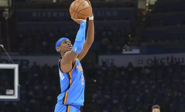 Oklahoma City Thunder guard Shai Gilgeous-Alexander, left, shoots during the first half in Game 1 of an NBA first-round playoff series against the Memphis Grizzlies, Tuesday, April 22, 2025, in Oklahoma City. (AP Photo/Kyle Phillips)
