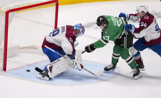 Dallas Stars right wing Evgenii Dadonov (63) sneaks the puck by Colorado Avalanche goaltender Mackenzie Blackwood (39) for a goal as left wing Joel Kiviranta (94) tries to defend during the third period in Game 2 of a first-round NHL hockey playoff series Monday, April 21, 2025, in Dallas. (AP Photo/Julio Cortez)