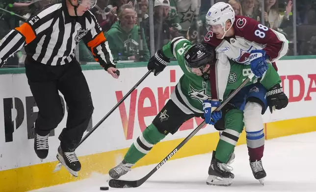 Colorado Avalanche center Martin Necas (88) and Dallas Stars center Sam Steel (18) compete for possession as referee Graham Skilliter (24) tries to get away during the first period in Game 2 of a first-round NHL hockey playoff series Monday, April 21, 2025, in Dallas. (AP Photo/Julio Cortez)