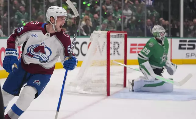 Colorado Avalanche defenseman Ryan Lindgren, left, reacts after shot by teammate center Jack Drury, not visible, entered the net of Dallas Stars goaltender Jake Oettinger, right, for a goal during the second period in Game 2 of a first-round NHL hockey playoff series Monday, April 21, 2025, in Dallas. (AP Photo/Julio Cortez)