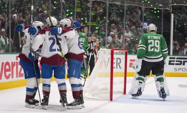 Colorado Avalanche players celebrate a goal by Logan O'Connor (25) as Dallas Stars goaltender Jake Oettinger (29) skates on his crease during the second period in Game 2 of a first-round NHL hockey playoff series Monday, April 21, 2025, in Dallas. (AP Photo/Julio Cortez)