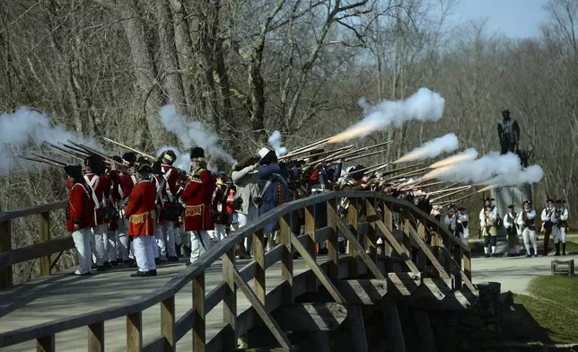 FILE - Acton Minutemen and British soldiers fire a ceremonial volley from the North Bridge, after the re-enactment of the North Bridge fight marking the 241st anniversary of the start of the American Revolutionary War, Monday, April 18, 2016, in Concord, Mass. (John Walker/The Metro West Daily News via AP,File)