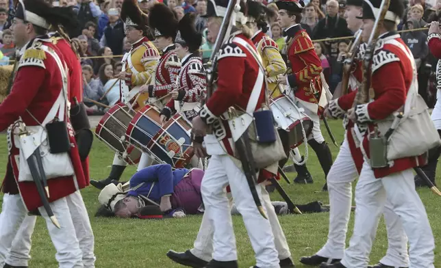 FILE - The British march off to Concord, leaving Lexington militia dead or dying on Lexington Green during a reenactment of the Battle of Lexington, Monday, April 17, 2017, in Lexington, Mass. (Ann Ringwood/The Metro West Daily News via AP,File)