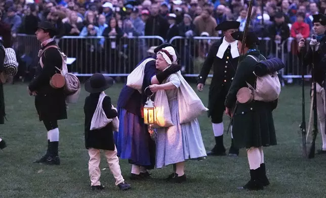 Colonials embrace while gathering prior to facing the British Regulars during a reenactment celebration of the 250th anniversary of the Battle of Lexington and start of the American Revolution, Saturday, April 19, 2025, in Lexington, Mass. (AP Photo/Charles Krupa)