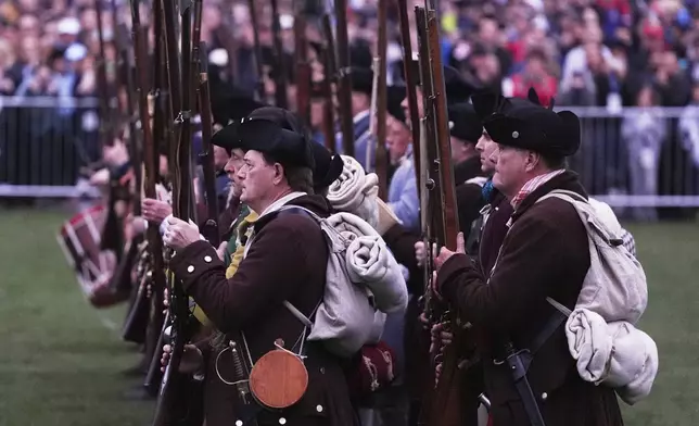 New England colonial militia, also known as a Minuteman, stand in line while facing the British Regulars during a reenactment celebration of the 250th anniversary of the Battle of Lexington and start of the American Revolution, Saturday, April 19, 2025, in Lexington, Mass. (AP Photo/Charles Krupa)