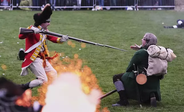 While a rifle fires, a British Regular stabs a New England colonial militia, also known as a Minuteman, during a reenactment celebration of the 250th anniversary of the Battle of Lexington and start of the American Revolution, Saturday, April 19, 2025, in Lexington, Mass. (AP Photo/Charles Krupa)