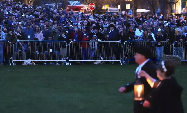 Thousands watch before sunrise during a reenactment celebration of the 250th anniversary of the Battle of Lexington and start of the American Revolution, Saturday, April 19, 2025, in Lexington, Mass. (AP Photo/Charles Krupa)
