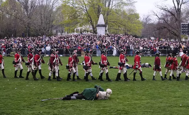 British Regulars march past a fallen New England colonial militia, also known as a Minuteman, during a reenactment celebration of the 250th anniversary of the Battle of Lexington and start of the American Revolution, Saturday, April 19, 2025, in Lexington, Mass. (AP Photo/Charles Krupa)