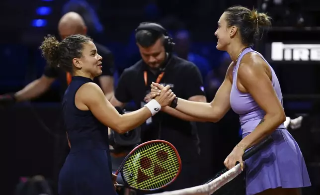 Aryna Sabalenka of Belarus, right, and Jasmine Paolini of Italy shake hands after the women's singles semi-final tennis match of the WTA tour, in Stuttgart, Germany, Sunday, April 20, 2025. (Marijan Murat/dpa via AP)
