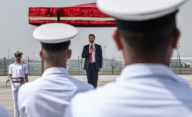 U.S. Vice President JD Vance places his hand over his heart as the American national anthem is played ahead of him reviewing troops upon his arrival in New Delhi, India, Monday, April 21, 2025. (Kenny Holston/The New York Times via AP, Pool)