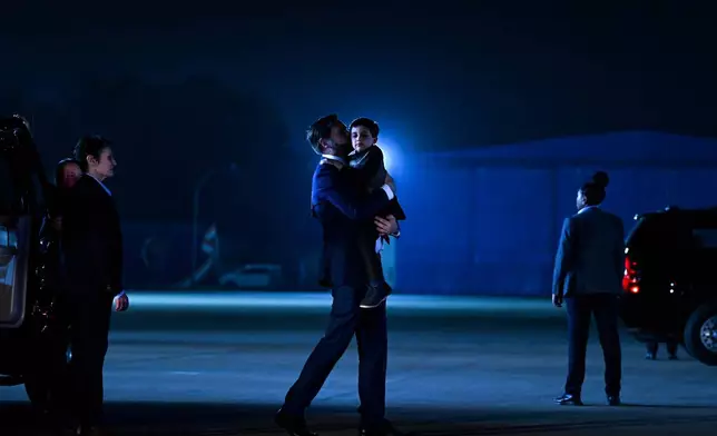 U.S. Vice President JD Vance carries his son Vivek across the tarmac to board Air Force Two en route to Jaipur, India, after spending the day in New Delhi, Monday, April 21, 2025. (Kenny Holston/The New York Times via AP, Pool)