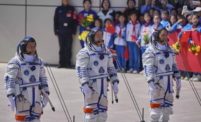 Chinese astronaut for the Shenzhou 20 mission, Chen Dong, center, speaks next to his comrades Chen Zhongrui, right, and Wang Jie as they attend a send-off ceremony for their manned space mission at the Jiuquan Satellite Launch Center in northwestern China, Thursday, April 24, 2025. (AP Photo/Andy Wong)
