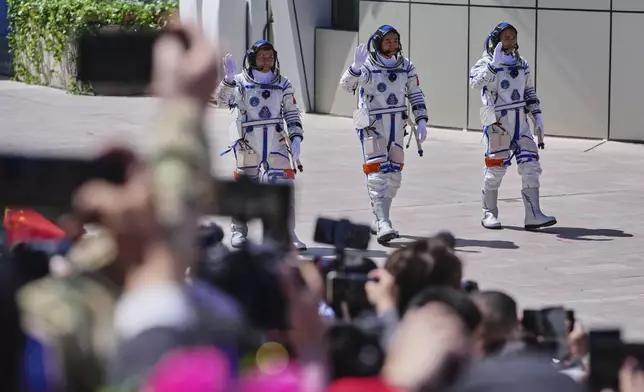 Chinese astronauts for the Shenzhou 20 mission, from right, Chen Zhongrui, Chen Dong and Wang Jie wave as they attend a send-off ceremony for their manned space mission at the Jiuquan Satellite Launch Center in northwestern China, Thursday, April 24, 2025. (AP Photo/Andy Wong)