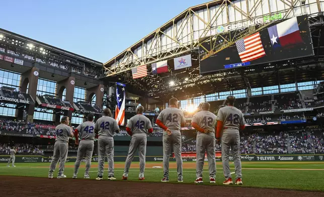 Los Angeles Angels players all wear number 42 in honor of Jackie Robinson Day as they observe the national anthem before a baseball game against the Texas Rangers, Tuesday, April 15, 2025, Arlington, Texas. (AP Photo/Albert Pena)