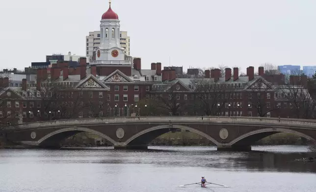 A sculler rows down the Charles River near Harvard University, at rear, Tuesday, April 15, 2025, in Cambridge, Mass. (AP Photo/Charles Krupa)