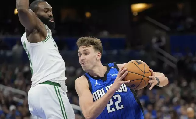 Orlando Magic forward Franz Wagner (22) goes past Boston Celtics guard Jaylen Brown during the second half in Game 4 of a first-round NBA basketball playoff series, Sunday, April 27, 2025, in Orlando, Fla. (AP Photo/John Raoux)