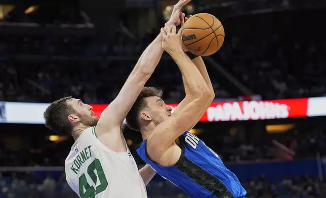 Orlando Magic forward Franz Wagner, right, loses control of the ball as he goes up against Boston Celtics center Luke Kornet (40) during the second half in Game 4 of a first-round NBA basketball playoff series, Sunday, April 27, 2025, in Orlando, Fla. (AP Photo/John Raoux)
