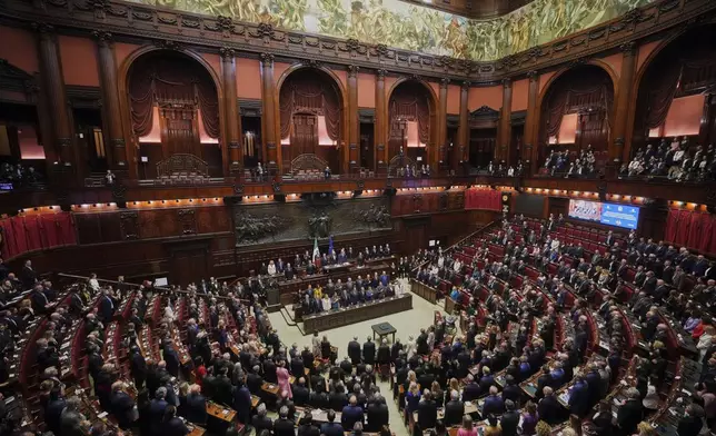 King Charles III, center top, stands with the membrs of the Italian Government as they listen to national anthems inside the Italian parliament in Rome, Wednesday, April 9, 2025. (AP Photo/Alessandra Tarantino)