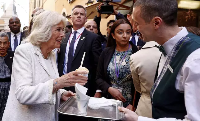 Queen Camilla is offered some gelato outside the Italian Parliament where King Charles III was delivering his address in Rome, Wednesday, April 9, 2025. (Reuters via AP, Pool)