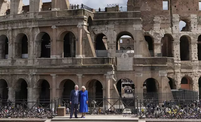 King Charles III, left, and Queen Camilla stand in front of the Colosseum, in Rome, Tuesday, April 8, 2025. (AP Photo/Gregorio Borgia)