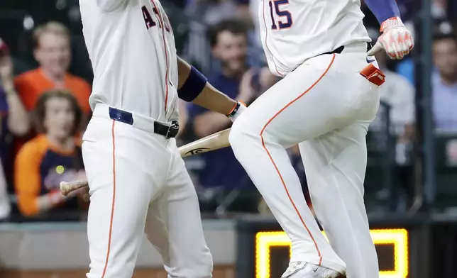 Houston Astros' Jeremy Pena, left, and Isaac Paredes (15) celebrate the solo home run by Paredes against the Toronto Blue Jays during the seventh inning of a baseball game Tuesday, April 22, 2025, in Houston. (AP Photo/Michael Wyke)