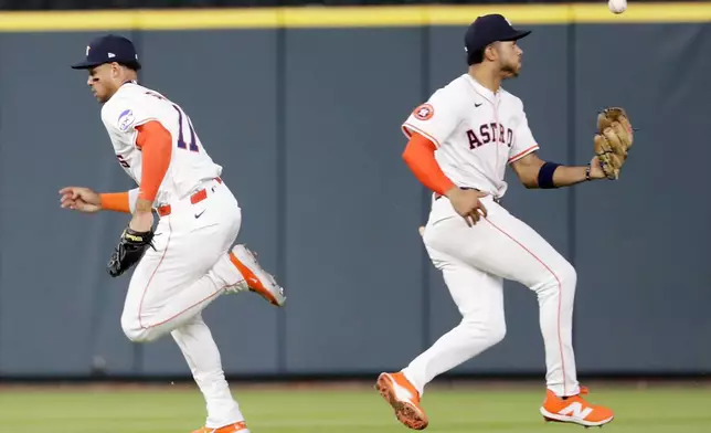 Houston Astros shortstop Jeremy Pena, right, juggles the catch as he crosses right fielder Cam Smith (11) on the fly ball by Toronto Blue Jays' Alan Roden during the fifth inning of a baseball game Tuesday, April 22, 2025, in Houston. (AP Photo/Michael Wyke)
